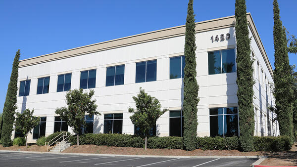 Exterior of a white, two-story building with parking lot