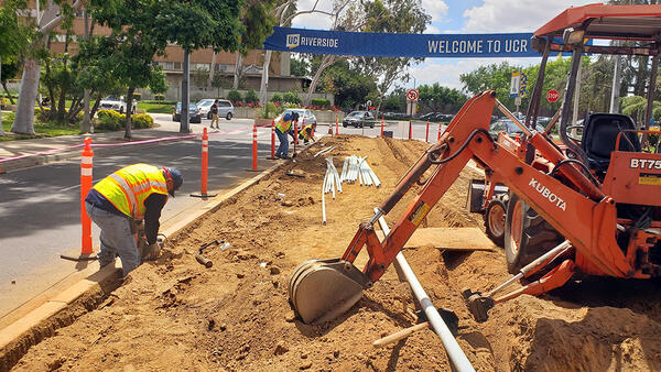 Landscapers digging trench for irrigation by hand and with equipment