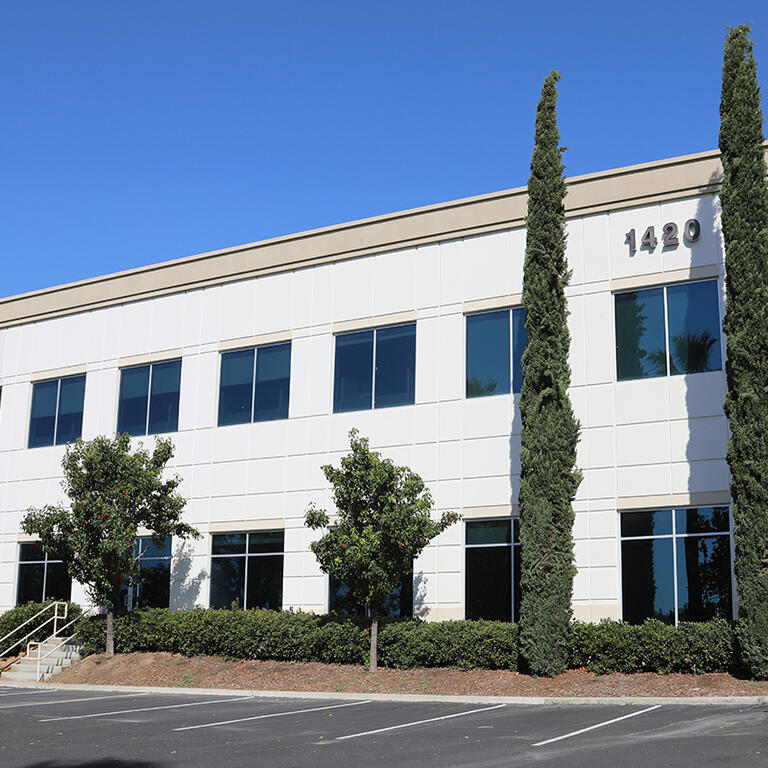 Exterior of a white, two-story building with parking lot