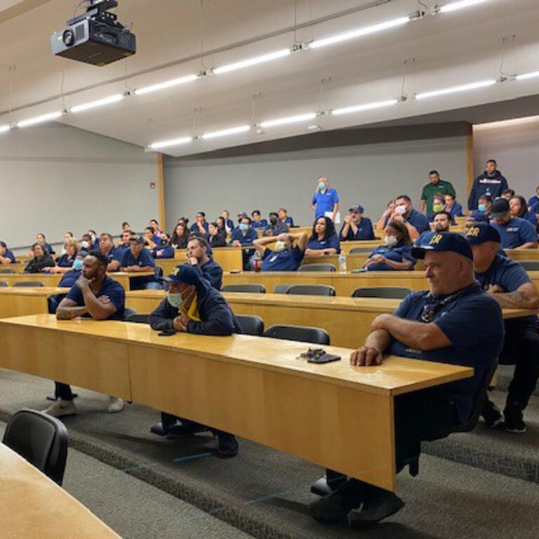 Custodians sitting in chairs in a lecture hall