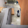 Custodial riding cleaning equipment in lobby of large building